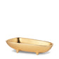 The AERIN Valerio Footed Bowl Collection features a small, bathtub-shaped, gold-colored bowl with three short legs, perfect for serving snacks and adding a touch of elegance to your entertaining.