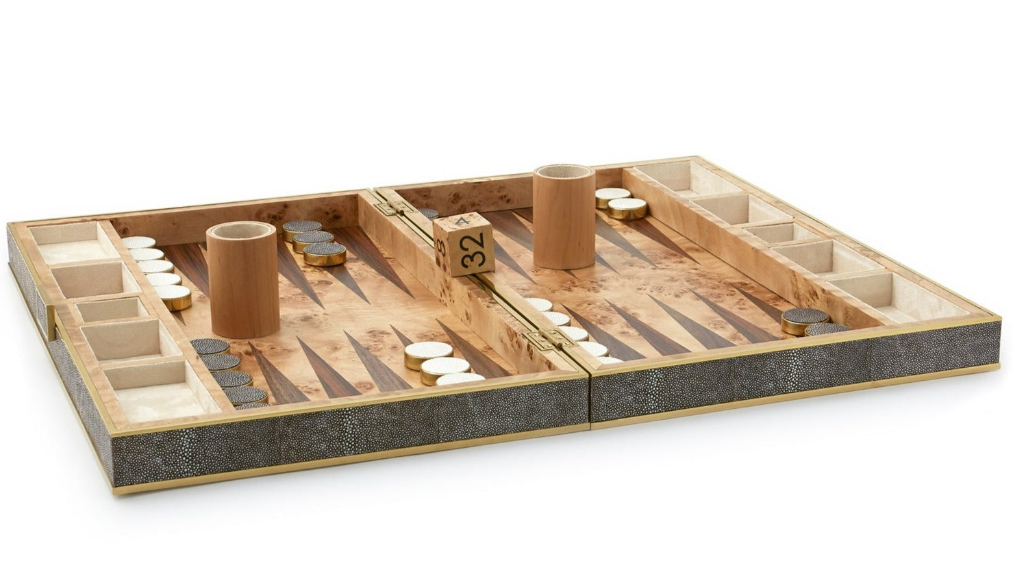 A stylish AERIN Shagreen Backgammon Set, Chocolate, featuring black and white checkers, two cups, and a doubling cube arranged on a wooden board.