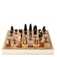 A luxurious AERIN Shagreen Chess Set featuring unique geometric gold-plated pieces on a wooden board with a cream border.