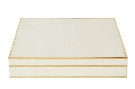 A luxurious AERIN Shagreen Chess Set housed in a closed, off-white rectangular box with gold trimming on the edges.