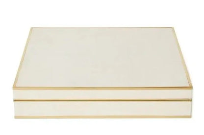 A luxurious AERIN Shagreen Chess Set housed in a closed, off-white rectangular box with gold trimming on the edges.