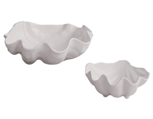 The Beatriz Ball VIDA Ocean Shell Serveware Collection, featuring two white ceramic bowls shaped like scallop shells with one larger than the other, is positioned on a plain backdrop. They're ideal for serving seafood salads at your next entertainment gathering.
