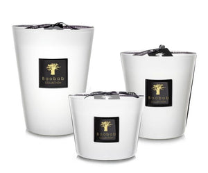 Three white Baobab Collection Les Prestigieuses Pierre De Lune candles of varying sizes with black labels and ribbon wicks, each exuding a subtle floral scent that transports you to a dreamlike realm.