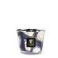 A decorative candle in a marbled blue and white glass container with a black label reading "Baobab Collection Stones Lazuli Candle," releases hints of cardamom, adding a touch of exotic spice to its elegant presentation.