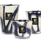 Three Baobab Collection Stones Lazuli Candles, with blue and white marbled patterns, in varying sizes. Infused with the captivating scents of cardamom and musk, these candles offer a serene and aromatic ambiance for any space.