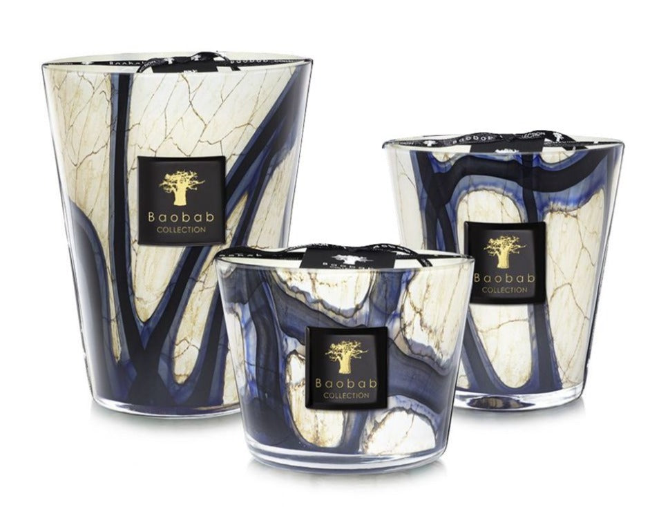 Three Baobab Collection Stones Lazuli Candles, with blue and white marbled patterns, in varying sizes. Infused with the captivating scents of cardamom and musk, these candles offer a serene and aromatic ambiance for any space.