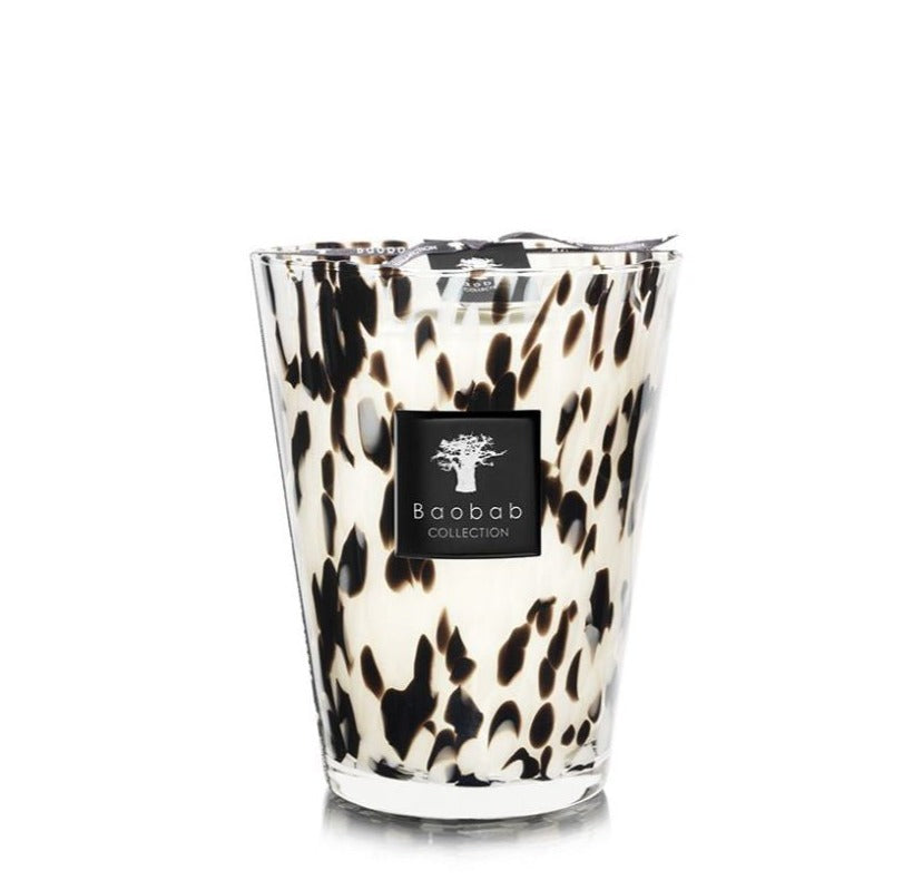 A large Baobab Collection Pearls Black Candle in a glass holder with a black and white spotted design, inspired by Black Pearls.