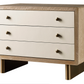 A Waterfall Nightstand with a natural wood frame, three white drawers, and brass handles, supported by brass legs.