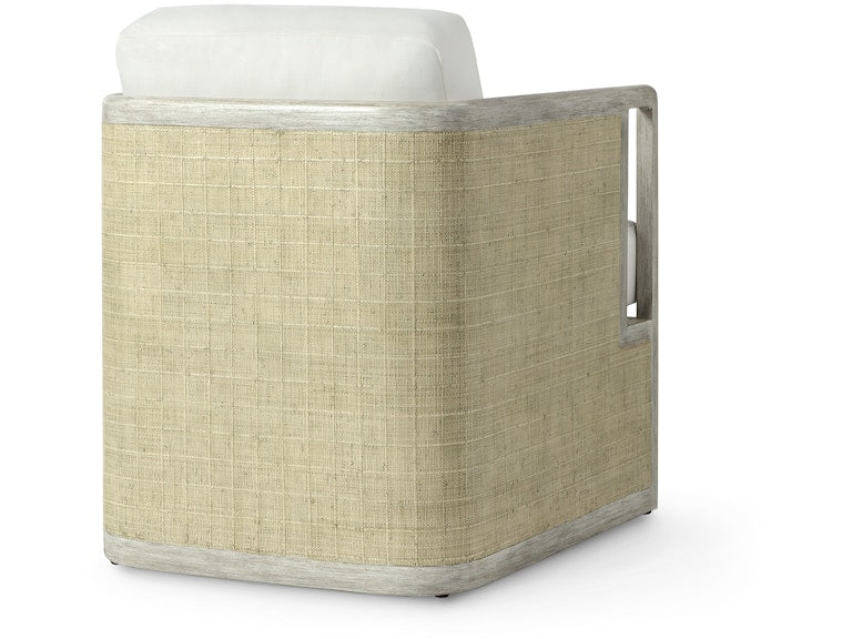 The Aveline Lounge Chair features light-colored woven sides, a white cushion, and a two-tone hardwood frame, shown from an angled side view.