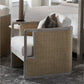 The Aveline Lounge Chair features a hardwood frame, woven side panels, and white cushions, shown on a gray rug in a bedroom.