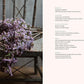 A bundle of purple flowers rests on a rustic wooden chair. To the right, a spring-themed menu inspired by Lemon Apron Cookbook is listed with various dishes under categories such as Breakfast, Appetizers, Soup and Simmer, Salad and Side, Main, and Dessert.