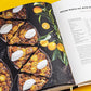 Open cookbook displaying a recipe for "Pecan Maple Pie with Kumquats," featuring an image of sliced pecan pies with whipped cream and kumquats beside the recipe text. This baking book, *Tartine: A Classic Revisited*, also includes gluten-free variations for classic Tartine recipes.