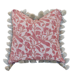 The Peacock Garden Pillow is a square decorative pillow showcasing a pink floral pattern and beige tassels along the edges, featuring a hidden zipper closure for a seamless look, displayed against a white background.