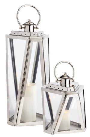 Two Napa Adler Steel Outdoor Lanterns of varying heights, each with a sleek chrome finish and white LightLi pillars inside, are displayed side by side.