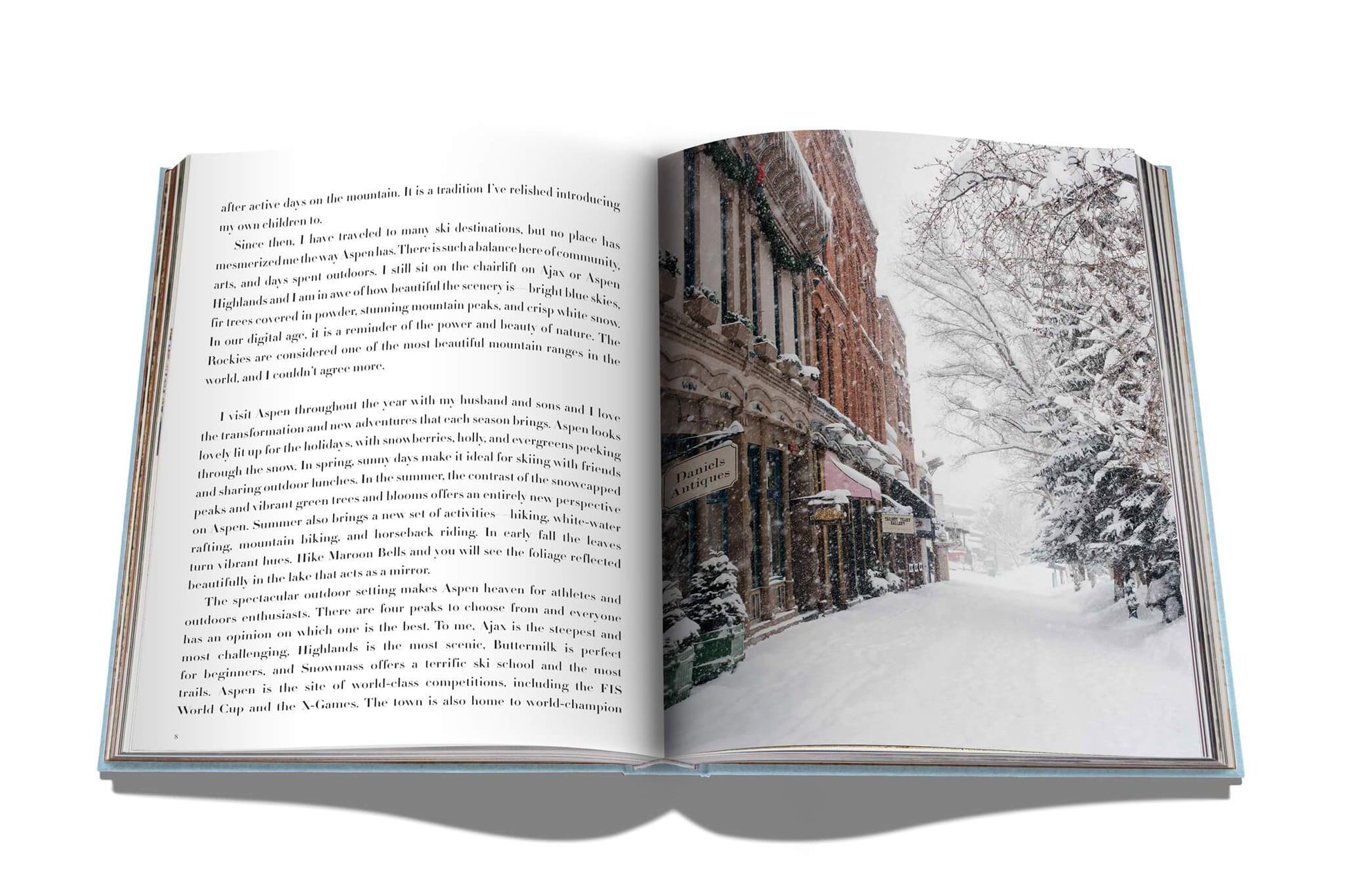 An open book with a picture of a snow-covered street, reminiscent of Assouline's Aspen Style.