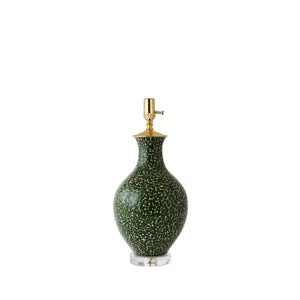 The Athens Large Green Dappled Lamp features a green ceramic base with a speckled pattern, gold hardware, and a clear round pedestal. Shown without a lampshade, it highlights artistic ceramic craftsmanship.