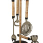 A Be Home Arendal Bar Collection with a strainer, mixing spoon, bottle opener, and jigger on a stand. Each tool boasts a metallic finish and wrapped handles, perfect for the master mixologist in your life. This elegant barware collection adds sophistication to any home bar setup.