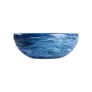 A bowl from the Denim Resin Serveware Collection with a blue marbled finish, smooth and glossy, makes a striking serving piece or accent for your decor. Shown against a white background.