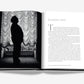 Open book displaying a black and white photo of a person standing in front of curtains on the left page and text introduction on the right page, highlighting the fashion treasures of Dior: Gianfranco Ferre.