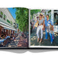 Open book showing two pages: left page depicts people dining at an outdoor café on a brick-paved street in The Hamptons; right page features two individuals posing for a photo while standing outdoors, exuding boho-chic luxury leisure. Hamptons Private.