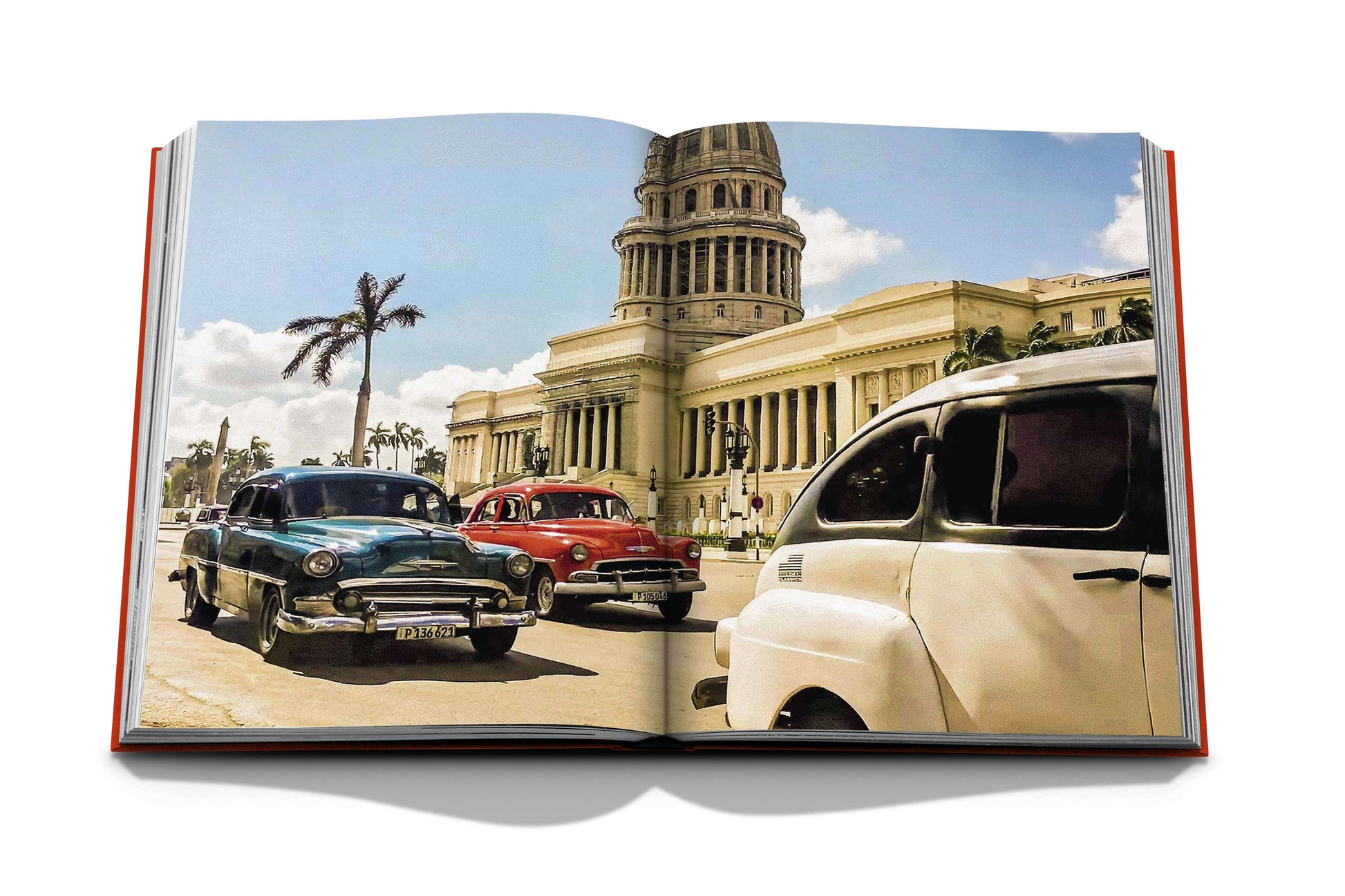 An open book displaying an image of vintage cars driving in front of a neoclassical building with a prominent dome, evoking the vibrant streets of Havana during its cultural renaissance, Havana Blues.