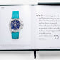 An open book displays a luxury Rolex wristwatch on one page and a quote about time by Kahlil Gibran on the other. "The Impossible Collection of Rolex" is encased in a green box with a black ribbon bookmark.