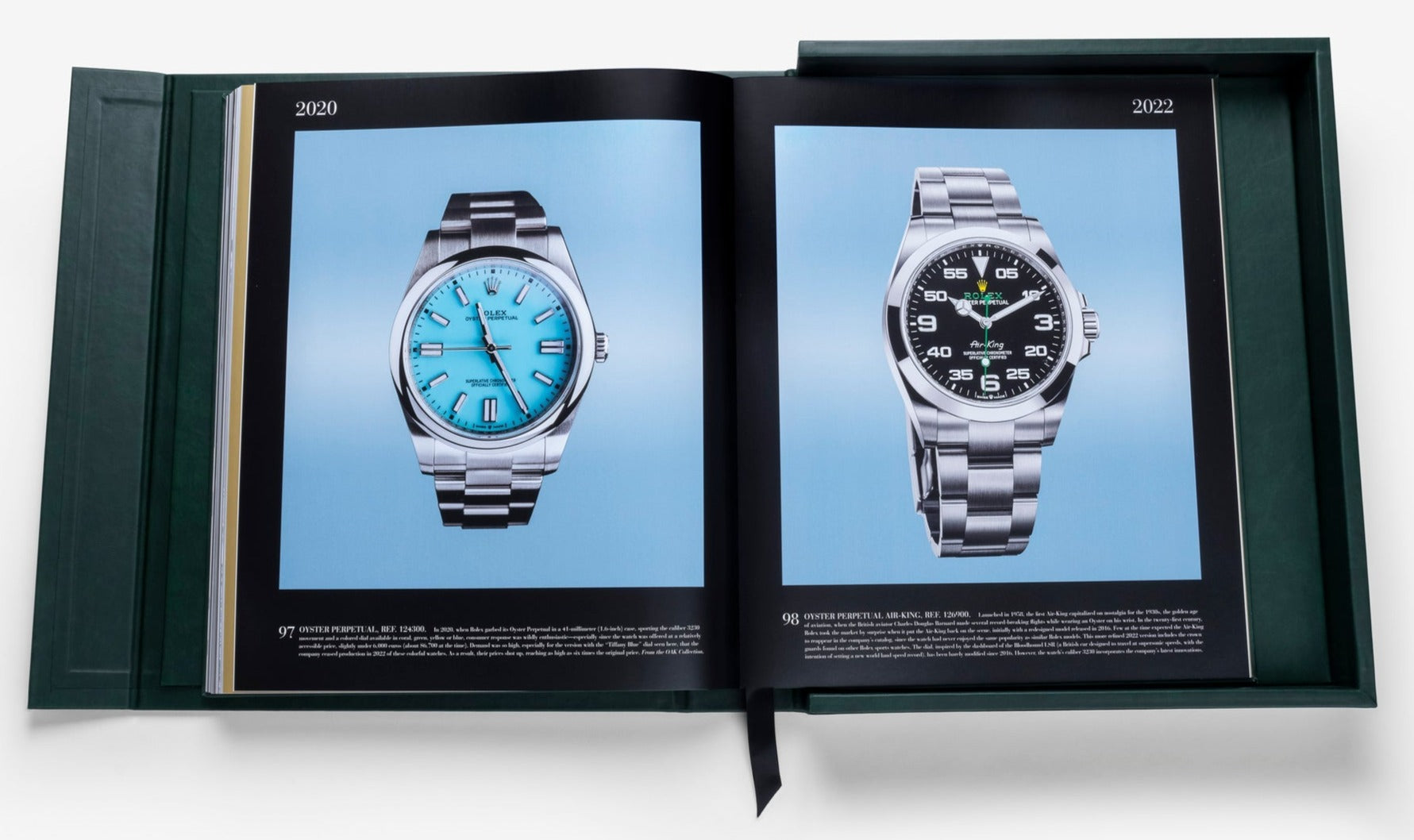 Open book displaying two luxury timepiece models on light blue backgrounds, with the left page showcasing a silver watch with a turquoise face from 2020, and the right page displaying a similar watch from 2022, both under The Impossible Collection of Rolex.