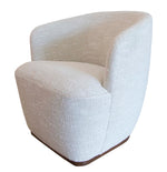 A modern, light-colored Samantha Swivel Chair with a curved back, wooden base, and swivel chair feature.