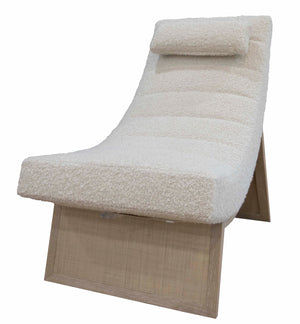 A Sway Lounge Chair with a slanted backrest, head cushion, and textured off-white upholstery, supported by a wooden frame with an angled base in quartered oak veneer.