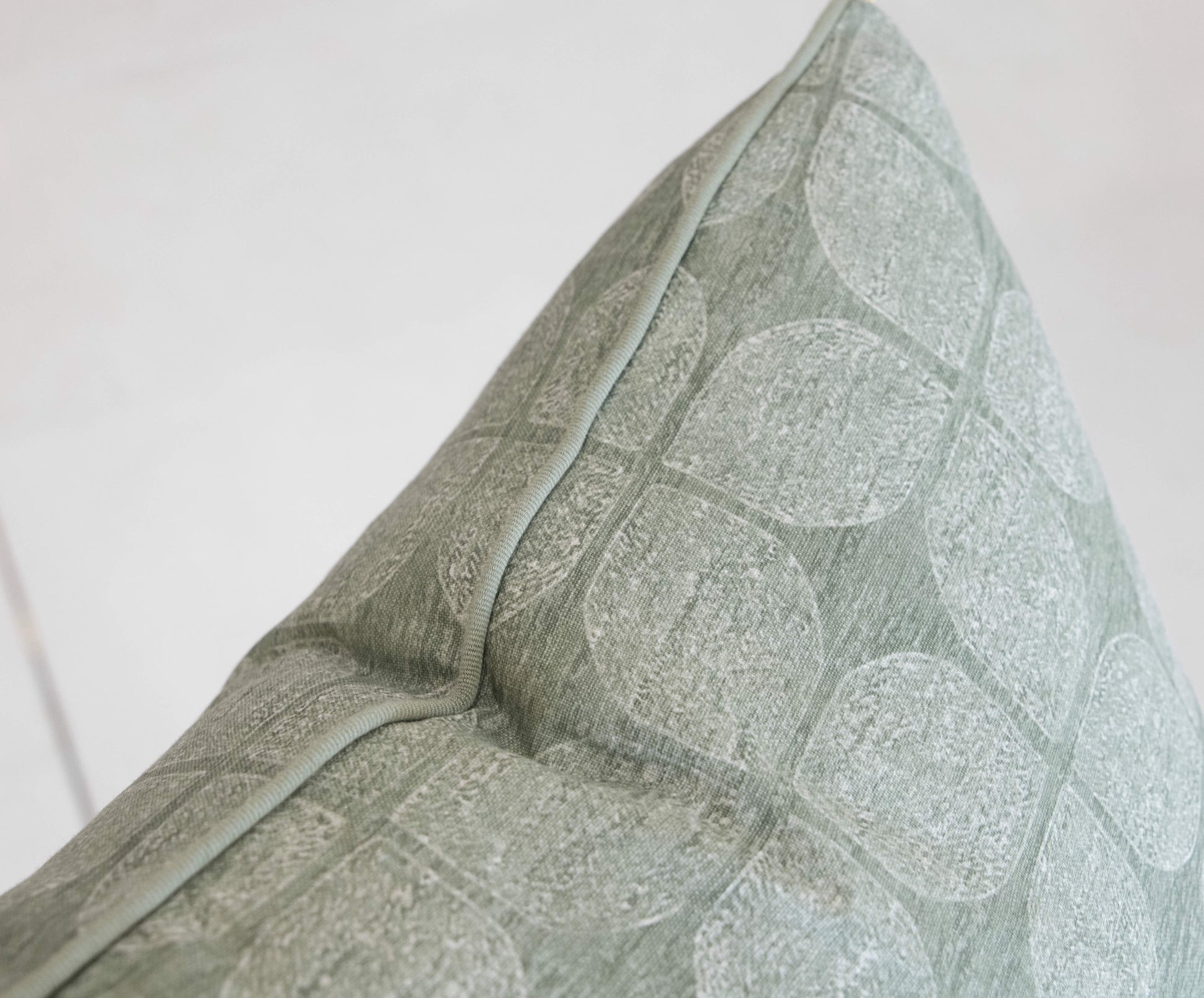 Close-up of a Petaluma Moss Pillow with a textured, circular pattern, custom-made from the finest materials and crafted with special attention to detail, against a light background.
