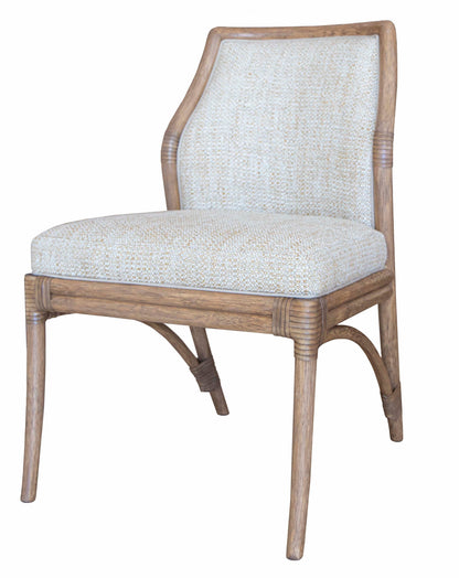 The Lantana Side Chair, showcasing McGuire craftsmanship, is a wooden chair with a cushioned seat and backrest, featuring a light fabric covering and a simple, curved design that embodies flexible modern design.