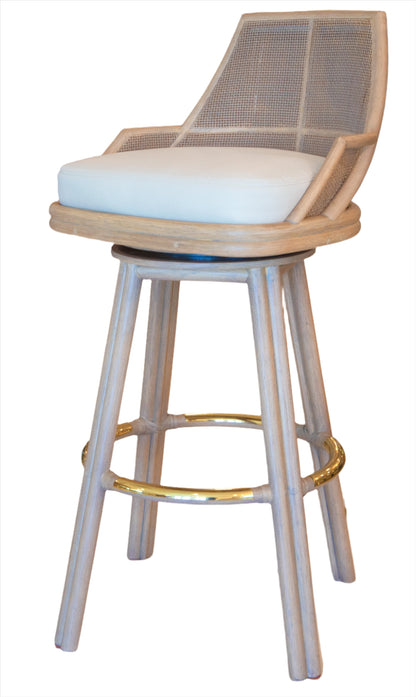 The Hayes Barstool features a wooden structure with a cream cushion and a round, gold-colored footrest. The backrest showcases an intricate caned interior design, adding an elegant touch to its timeless appeal.