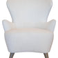 The Ollie Chair is a white, modern armchair with a wide, curved backrest and wooden legs, blending easy style with the elegance of a classic wing chair.