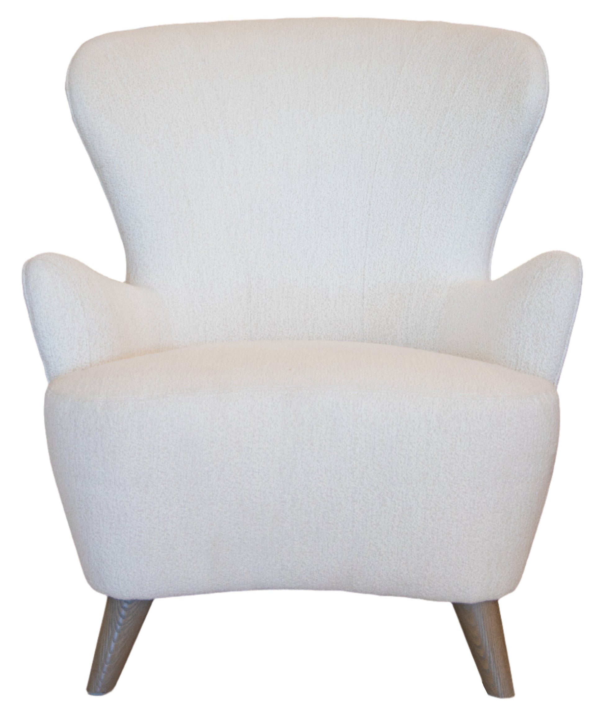 The Ollie Chair is a white, modern armchair with a wide, curved backrest and wooden legs, blending easy style with the elegance of a classic wing chair.