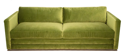 The Marquesa Sofa, a modern interpretation of elegance, features a green velvet design with two seat cushions, two back cushions, and square armrests on each side—perfect for a luxe setting.