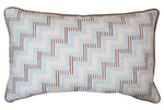 The Ziggy Sky Lumbar Pillow features a geometric zigzag pattern in light blue, cream, and brown with dark edge piping, crafted from premium materials—ideal for adding stylish custom-made flair to your space.