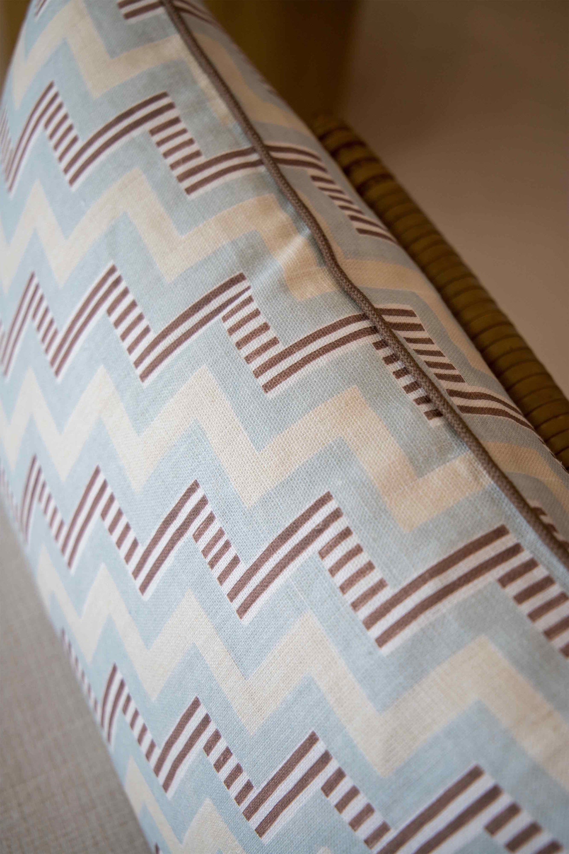 Close-up of the Ziggy Sky Lumbar Pillow, featuring a blue, white, and brown zigzag pattern on a light fabric—perfect for enhancing your pillow collection with style.