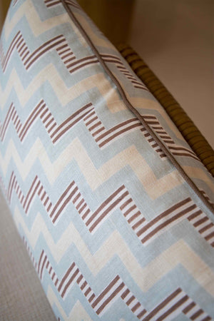 Close-up of the Ziggy Sky Lumbar Pillow, featuring a blue, white, and brown zigzag pattern on a light fabric—perfect for enhancing your pillow collection with style.