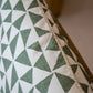 Close-up of the Circus Lumbar Pillow, featuring a geometric pattern of green triangles on a white background, crafted from premium materials with a visible seam along one edge.