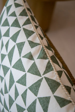 Close-up of the Circus Lumbar Pillow, featuring a geometric pattern of green triangles on a white background, crafted from premium materials with a visible seam along one edge.
