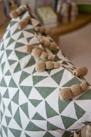 Close-up of our Circus Pillow, custom-made with a green and white geometric pattern and beige tassels, crafted from the finest materials.