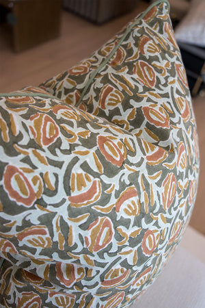 A close-up of two Marbella Eucalypt Pillows, custom-made with premium materials and showcasing a green, orange, and beige floral patterned fabric.