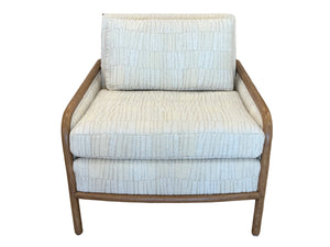 Front view of the Stinson Lounge Chair in Napa White, showcasing light beige textured cushions and luxurious upholstery with a refined wooden and rattan frame, set against a white background.
