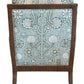 The St. Germain Lounge Chair is shown from the back, highlighting its wooden frame and green and white fabric with a French-inspired floral and shell pattern.