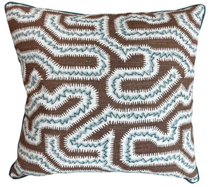The Moorish Maze Pillow features a brown background with an abstract zigzag pattern in white and light blue stitching, custom-made from premium materials for comfort and style.