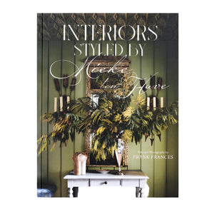 The cover of "Interiors: Styled by Mieke ten Have" features a green wall, floral arrangements inspired by Flowers for Living, a mirror, and a white console table.