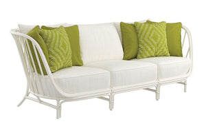 The Janus Et Cie Kyoto Alu 3 Seat Sofa, crafted with durable JANUSFIBER and featuring three white cushions along with five green decorative pillows, stands elegantly against a pristine white background.