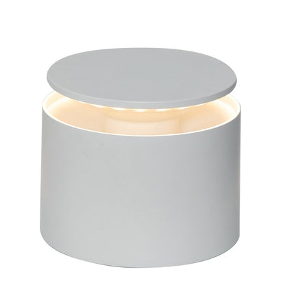 The Zafferano PushUp Pro Lamp Collection features a cylindrical white rechargeable table lamp with a flat, circular top and soft light glowing from beneath the lid.