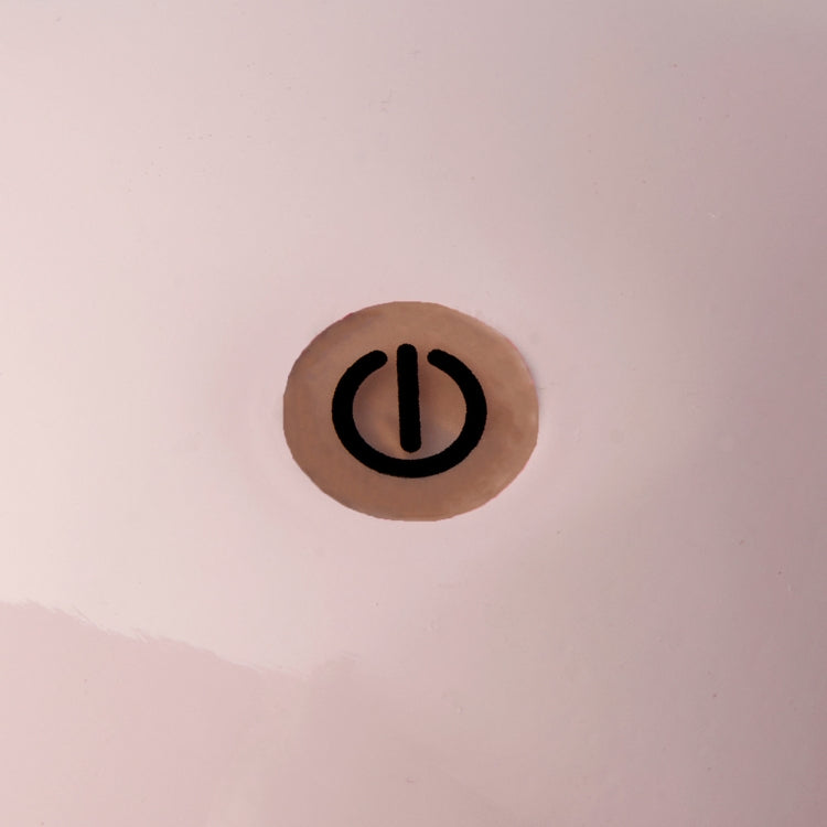 A black power button inside a beige circle on a smooth, light pink base highlights the sleek design of the Addison Ross Bobbin LED Cordless Lamp.