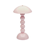 The Addison Ross Bobbin LED Cordless Lamp is a pink portable light with a dome-shaped shade, stacked spherical base inspired by bobbin lamps, and a glossy finish.